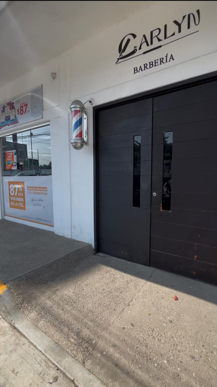 Fachada principal de Barbería Carlyn con poste de barbero tradicional en Ex-Glorieta, Santa Irene