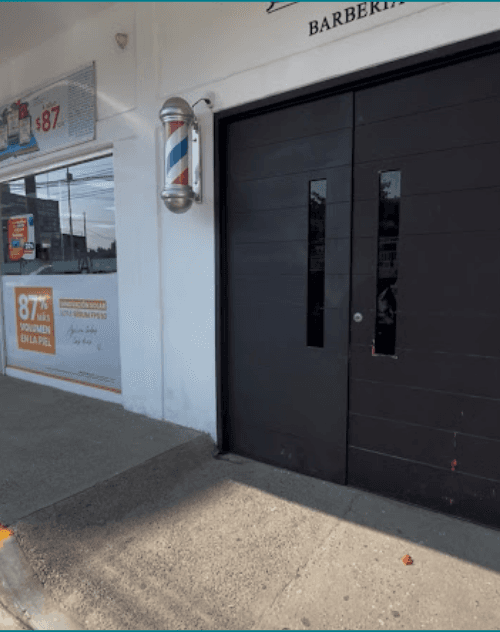 Detalle del acceso y puerta de entrada en Barbería Carlyn sucursal Ex-Glorieta